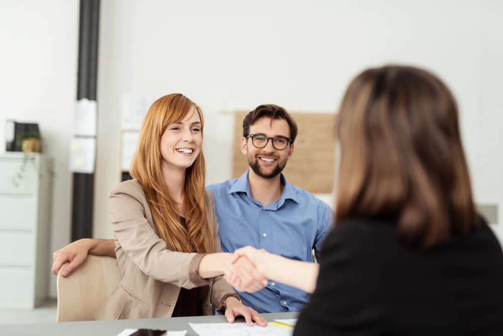 Happy young couple meeting with a broker